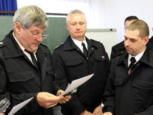 Harald Heinen, Leiter der Feuerwehr der Gemeinde Kall (links), überreicht dem neuen Brandmeister Rene Jerratsch (rechts) die Beförderungsurkunde und die neuen Dienstgrad-Abzeichen. Foto: Reiner Züll