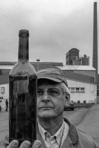 Der Betriebsratsvorsitzende Heinz Keupgen betrachtete 2008 auf dem Vorfeld der Glashütte die letzte vom Fließband gelaufene Weinflasche. Foto: F.A. Heinen
