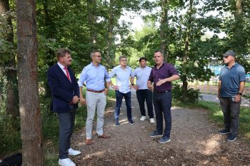 Bürgermeister Sacha Reichelt (2.v.r.) erklärte die Baumaßnahmen am neuen Skaterpark und am Pumptrack und bedankte sich besonders bei Karl-Heinz Daniel (links) für die große Unterstützung durch die Kultur- und Sportstiftung, die sich bei der Skateranlage ins Zeug gelegt hatte. Bild: Michel Thalken/Eifeler Presse Agentur/epa
