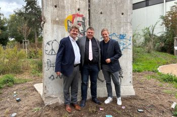 Geschichte lebendig werden lassen: KSK-Stiftungsvorstand Karl-Heinz Daniel (v. l.), Schulleiter Michael Mombaur und Landrat Markus Ramers vor den Original-Elementen der Berliner Mauer im Naturgarten der Marienschule. Foto: KSK Euskirchen