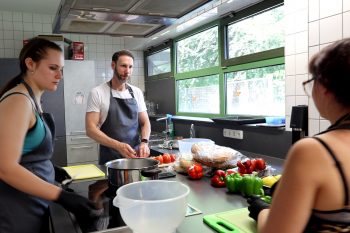 In der Küche half Daniel Ruland beim Zubereiten der Grillsalate und unterhielt sich mit den „Kolleginnen“ über deren Zukunftspläne. Bild: Michael Thalken/Eifeler Presse Agentur/epa