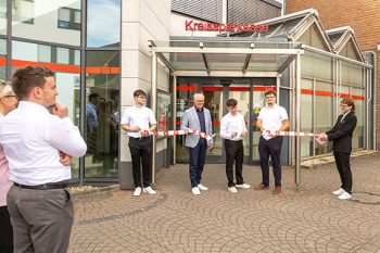 Mit dem symbolischen Akt des Band-Durchschneidens eröffnete Vorstandsvorsitzender Holger Glück (4.v.r.) zusammen mit den Azubi-BC-Leitern Niklas Fischer (3.v.r.) und Aris Walent (2.v.r.) das Azubi-BC Weilerswist. Bild: Tameer Gunnar Eden/Eifeler Presse Agentur/epa
