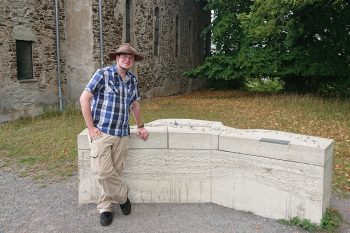 Der Autor und Lokalhistoriker Andreas Züll vor der Kirche und dem Dorfmodell in Wollseifen. Bild: Andreas Züll