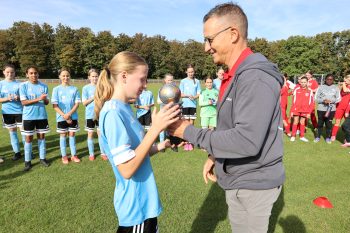 KSK-Vorstandsvertreter Jürgen Hübner übergab den Pokal an die Spielführerin des VfL Kommern. Bild: Michael Thalken/Eifeler Presse Agentur/epa