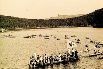 Paddler der ‚Deutschen Turnerschaft‘ auf dem Urftsee im Bereich der Staumauer. Die Vereinepräsentierten häufig ihre komplette Mannschaft dem Publikum an der Staumauer, bevor die Regatten begannen. Bild: AWVER.