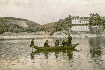 Eine Gesellschaft im Fährkahn vor der Kulisse des Hotels Lorbachtal. Bild: Familienbesitz Gretel Döbrich/Repro: Heinen