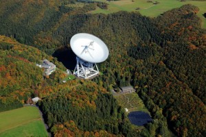 Radio-Observatorium Effelsberg mit dem 100-Meter-Radioteleskop. Links unten am Scheitelpunkt der Wiese ist der Besucherpavillon zu sehen, der Treffpunkt für die „Sternennacht“.  Foto: MPIfR. Peter Sondermann, VisKom/City-Luftbilder