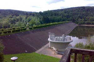 Der Staudamm am Kronenburger See muss saniert werden. Derzeit wird ein alternatives Verfahren geprüft, dass die Entleerung des Stausees zur Hauptsaison verhindern würde. Bild: Gemeinde Dahlem